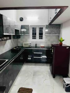 a kitchen with black cabinets and a sink at Apartment near LNT & CTC & Airport - 3F in Chennai