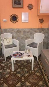 sala de estar con 2 sillas y mesa en Casa vacanze GioVa, en Martignano