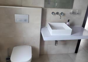 a bathroom with a white sink and a toilet at Stay Play Away Residences - Luxury 5 bed, Airport Residential in Accra