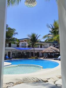 una piscina frente a un complejo con palmeras en Casa Marta Hotel, en Iloilo City
