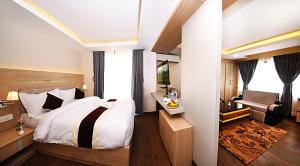 Divine Kathmandu Hotel في كاتماندو: غرفة نوم بسرير كبير ومكتب وكرسي