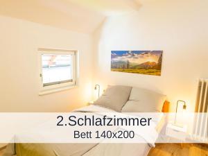 un dormitorio con una cama y una ventana en Ferienwohnung Rambold Sonnenterrasse, en Garmisch-Partenkirchen