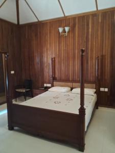 a bed in a room with a wooden wall at Jc Pool Villa in Kollam
