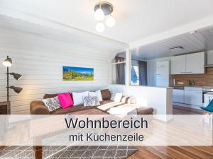ein Wohnzimmer mit einem Sofa und einer Küche in der Unterkunft Ferienwohnung Rambold Sonnenterrasse in Garmisch-Partenkirchen