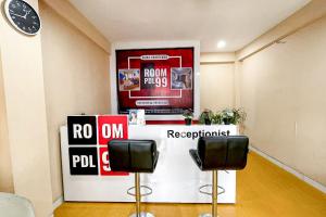 a room with two chairs and a counter with signs at Apartemen Riverview Cikarang by Room PDL 99 in Bekasi