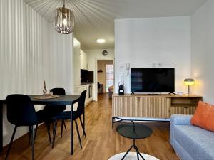 a living room with a couch and a table and a tv at sHome Apartments Graz - Self-Check-in & free parking in Graz
