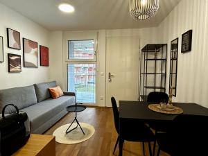 a living room with a couch and a table at SHOME Apartments Graz I Self Check-in I Free Parking in Graz +22 photos