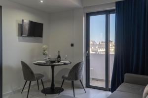 a living room with a table and chairs and a window at Aegean Stars in Rhodes Town