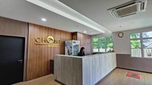 a woman standing at a counter in a lobby at C Hotel in Jitra