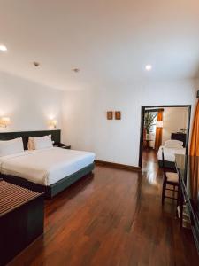 a hotel room with two beds and a mirror at Le Charme Vientiane Hotel in Vientiane