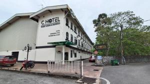 日得拉C酒店的一栋建筑前停着一辆摩托车