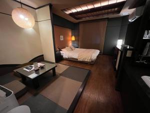 ein Hotelzimmer mit einem Bett und einem Tisch in der Unterkunft HOTEL SOLA Yame-ADULT ONLY-artificial hot spring- in Chikugo