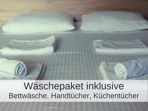 2 Betten mit weißen Kissen und Handtüchern darauf in der Unterkunft Ferienwohnung Rambold Sonnenterrasse in Garmisch-Partenkirchen
