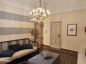 een slaapkamer met een bed en een kroonluchter bij Sotto la Torre - Under the Tower in Novi Ligure