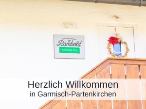 un cartel en una pared al lado de una escalera en Ferienwohnung Rambold Sonnenterrasse, en Garmisch-Partenkirchen