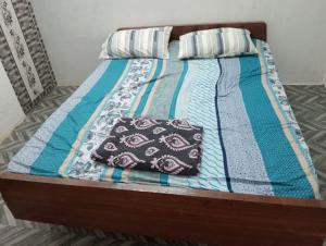 a bed with a quilt and pillows on it at KKA RESIDENCY in Coimbatore