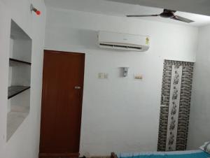 a room with a ceiling fan and a door at KKA RESIDENCY in Coimbatore