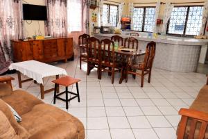 a living room with a table and chairs and a kitchen at Cs Apartment Mombasa Mtwapa in Mombasa