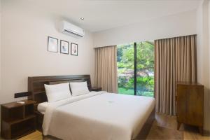 a bedroom with a white bed and a large window at Etereo Stays, Luxury Premium Apartments, Arpora, Goa in Arpora