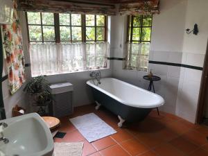 baño grande con bañera y lavamanos en Cherbury, en Winterton