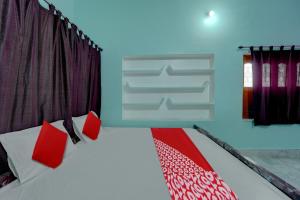 una camera da letto con un letto con cuscini rossi di OYO Flagship Magadh Guest House a Gaya