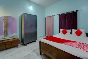 1 dormitorio con 1 cama, vestidor y TV en OYO Flagship Magadh Guest House, en Gaya
