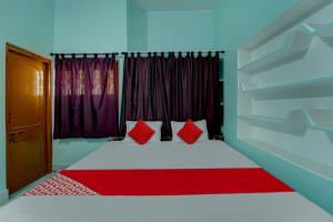 a bedroom with a bed with red pillows and a window at OYO Flagship Magadh Guest House in Gaya