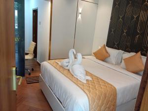 dos cisnes sentados en una cama en una habitación en Hotel ROYAL STAY en Thanjāvūr