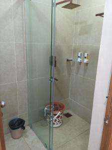 a shower with a glass door in a bathroom at Hotel ROYAL STAY in Thanjāvūr