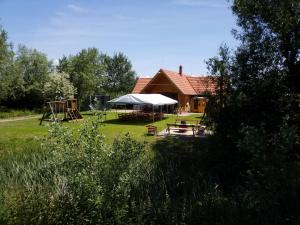 a house with a picnic table and a playground at Tómajor Vendégházak in Tiszaeszlár