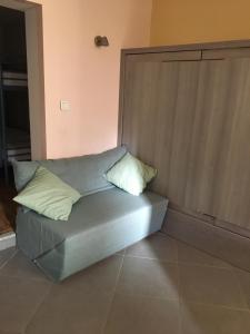 a couch with two pillows on it in a room at studio avec terrasse de 20 m2 in Vidauban