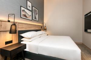 a bedroom with a bed and a table and a television at Four Points by Sheraton Bansko in Bansko