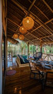 uma sala de estar com uma mesa e cadeiras e um sofá em Carabao Lodge - 2 bedroom house, stargazing & pool em El Nido