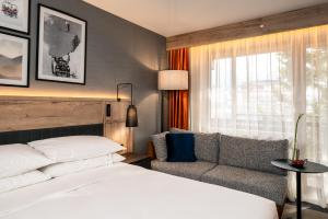 a hotel room with a bed and a couch at Four Points by Sheraton Bansko in Bansko