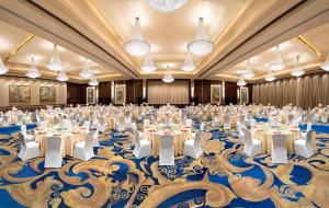 a large banquet hall with tables and chairs in a room with a blue carpet at Shangri-La Wenzhou in Wenzhou