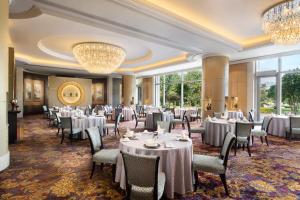 a dining room with tables and chairs and a chandelier at Shangri-La Wenzhou in Wenzhou