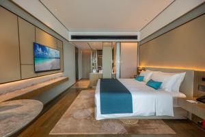 een slaapkamer met een groot bed en een televisie bij Blue Bay International Resort Hotel in Sihanoukville