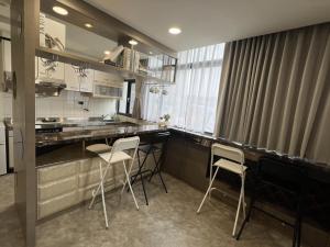 竹東鎮的住宿－Chill Place 二館，厨房配有柜台和椅子
