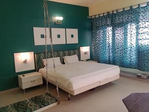 a bedroom with a swing bed and green walls at Hotel Airlines in Amritsar