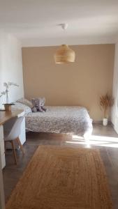 a bedroom with a bed and a desk and a rug at Une villa en Provence, piscine et jardin ombragé in Velaux