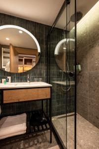 a bathroom with a shower and a sink and a mirror at Four Points by Sheraton Bansko in Bansko