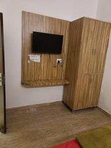 a wooden cabinet with a television on a wall at Hotel Royal shades in Chandīgarh