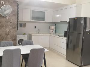 a kitchen with a table and a refrigerator at Summer Escapes in Johor Bahru