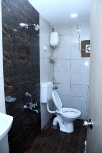 bagno con servizi igienici e lavandino di HOTEL NEW RATNAKAR a Daman