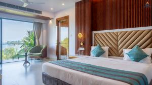 a bedroom with a large bed and a balcony at Hotel Atlanta - A Seaview Hotel in Port Blair