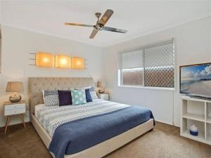 1 dormitorio con 1 cama y ventilador de techo en Bliss At The Bungalow, en Gold Coast