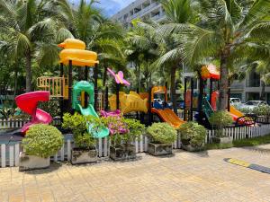 - un parc avec une aire de jeux avec des toboggans et des fleurs dans l'établissement Laguna Beach Resort 3 Condominium, à Jomtien Beach