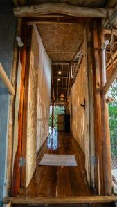 um corredor de uma casa com piso de madeira em Carabao Lodge - 2 bedroom house, stargazing & pool em El Nido