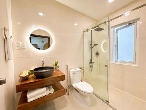 a bathroom with a toilet and a glass shower at AIRIE LIVING in Ho Chi Minh City