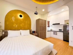 a bedroom with a large bed and a kitchen at AIRIE LIVING in Ho Chi Minh City